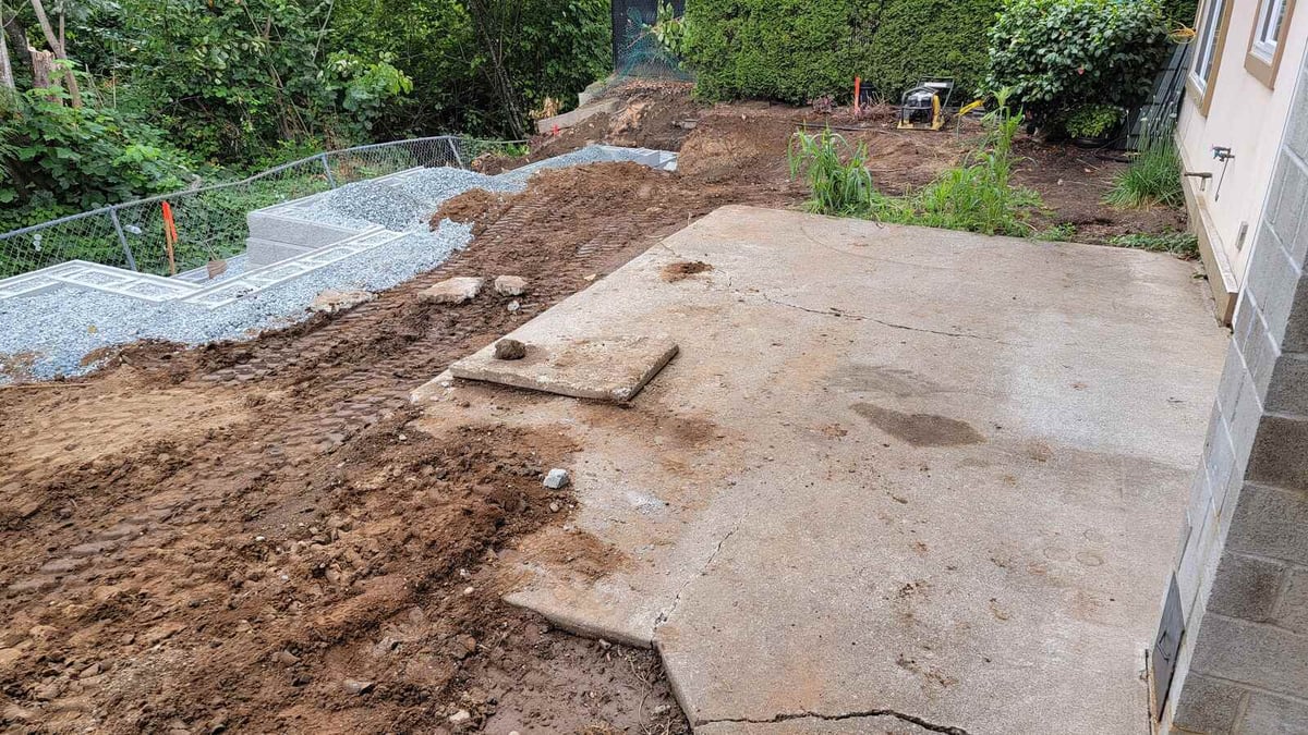 12_Prepped backyard ground with exposed soil and concrete patio in Abbotsford, BC, for a Back40 Landscaping project