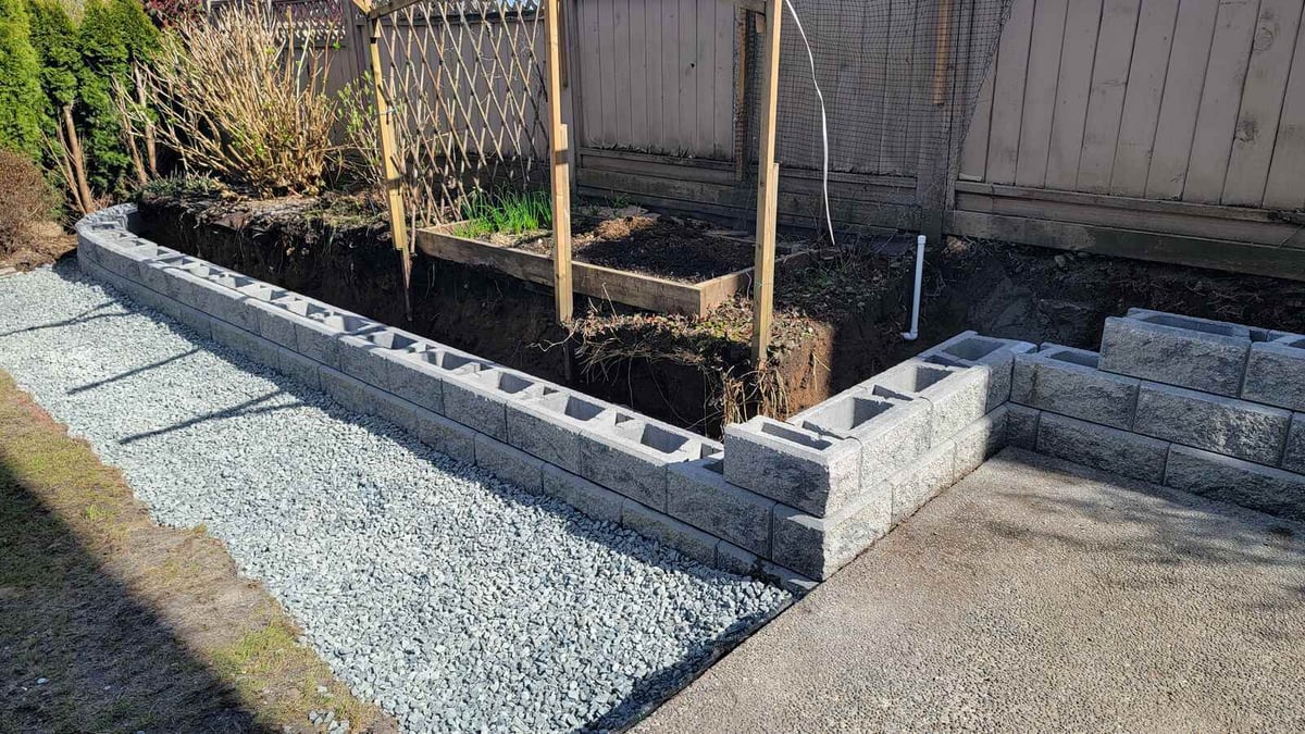 Progress on retaining wall installation with concrete blocks in Burnaby, BC, by Back 40 Landscaping