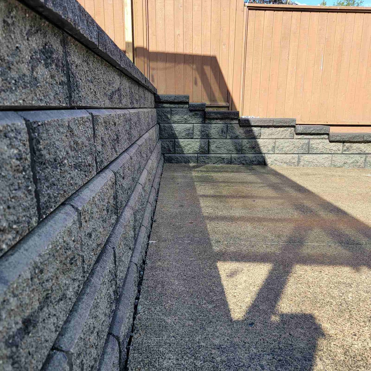 Langley backyard retaining wall with textured concrete blocks, constructed by Back 40 Landscaping