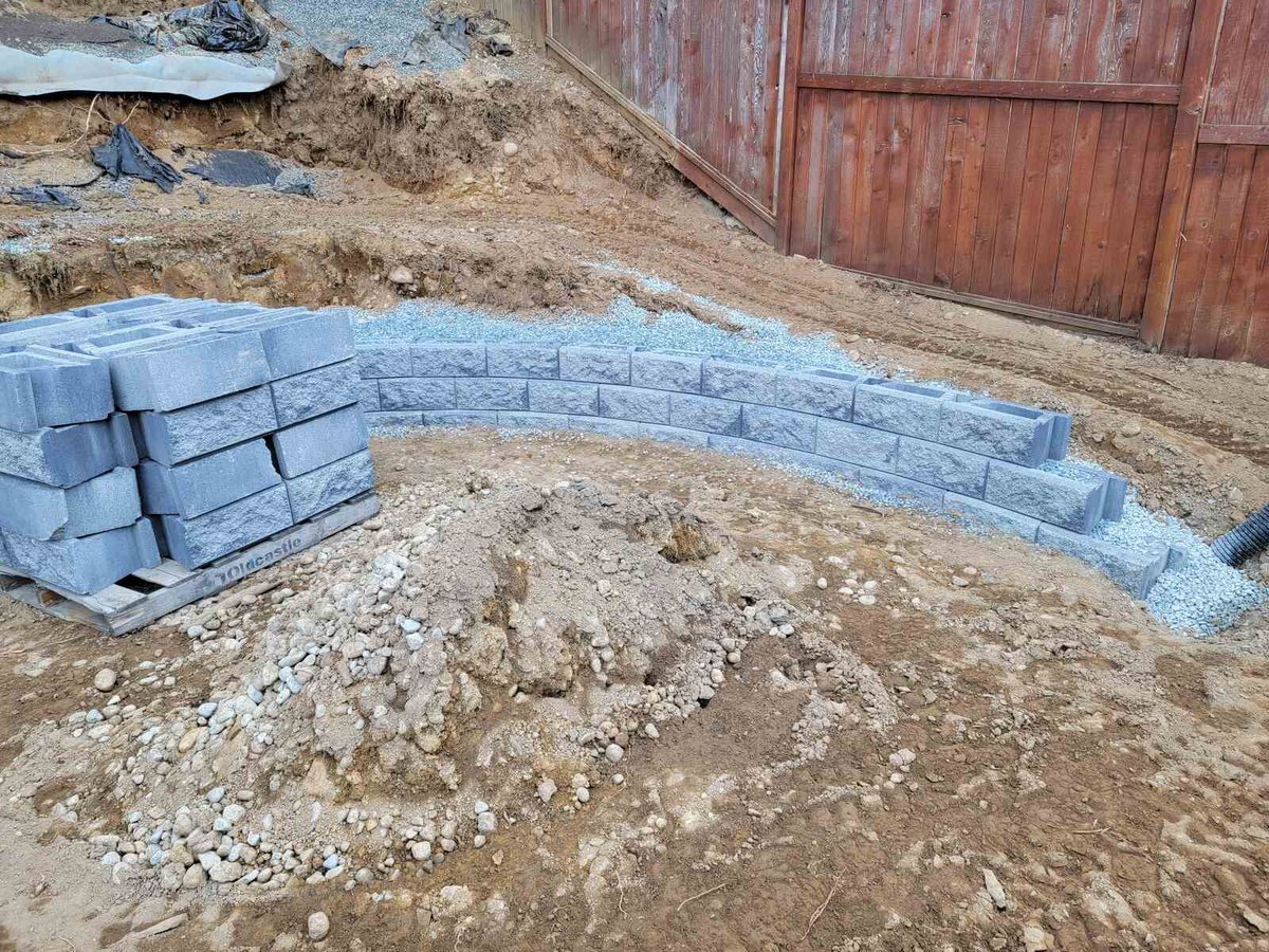 Stacked concrete blocks forming tiers for a retaining wall in Langley, BC by Back 40 Landscaping