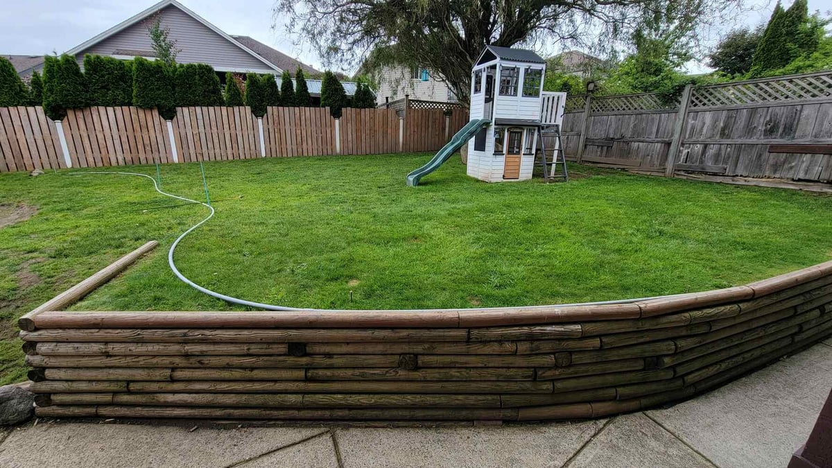 1_Backyard with a newly built retaining wall and playground, created by Back40 Landscaping in Mission, BC