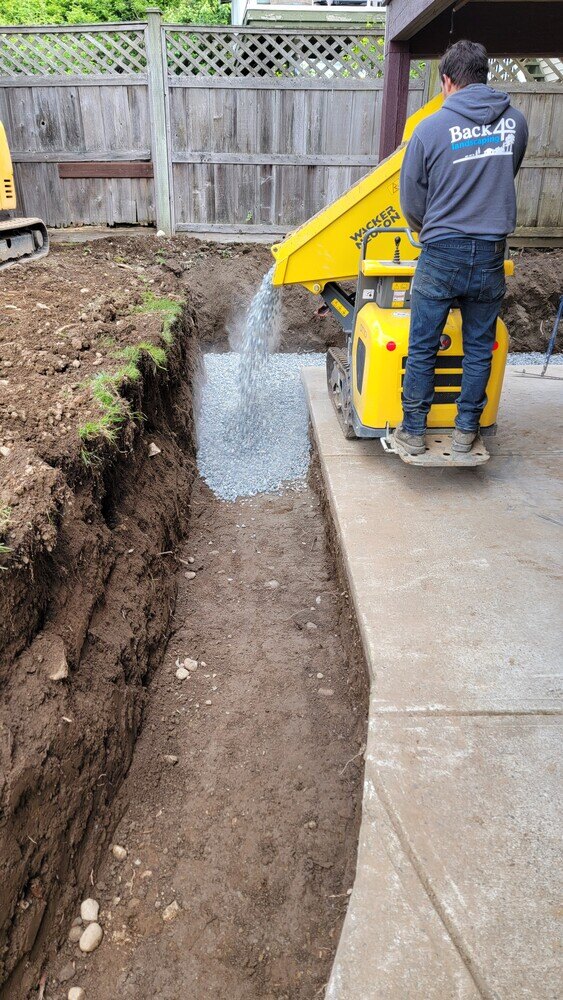 7_Retaining wall foundation setup with gravel and compacting equipment by Back40 Landscaping in Mission, BC